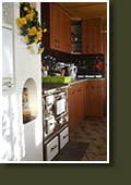 Kuchyně s kuchyňskou linkou a kuchyňskými kachlovými kamny
